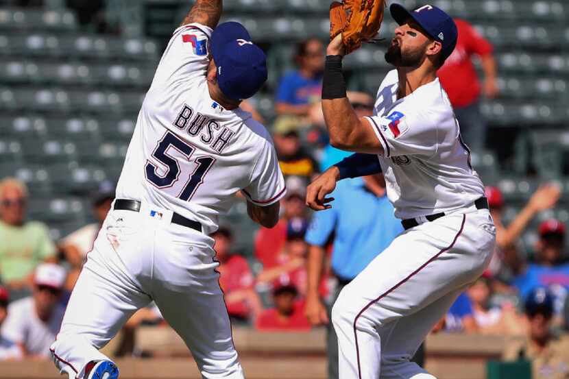 Texas Rangers relief pitcher Matt Bush (51) goes to catch an infield fly ball in front of...