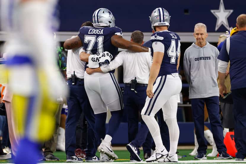 Dallas Cowboys guard Chuma Edoga (71) is helped to the sideline after suffering an injury...