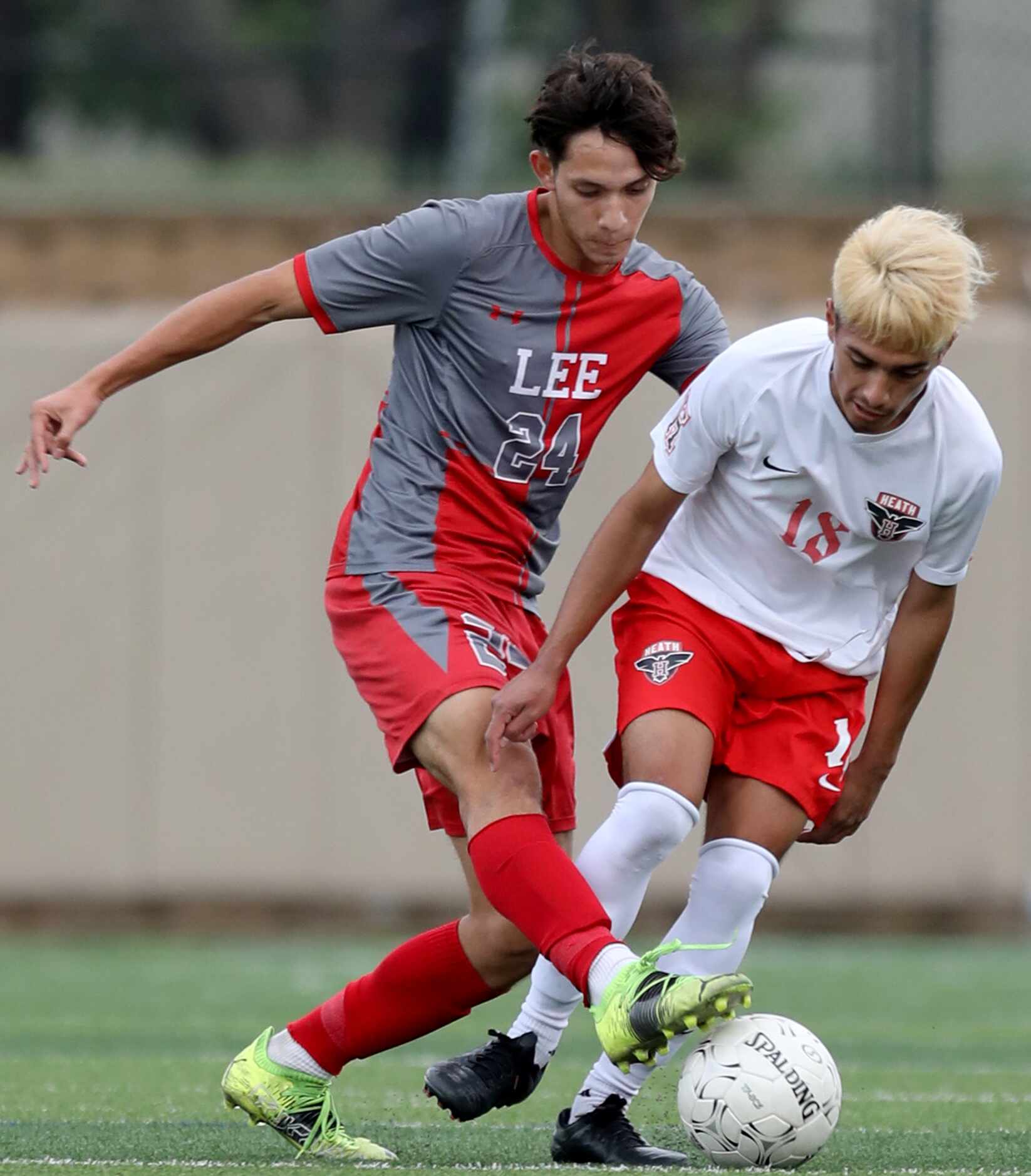 SA Lee's Julian Sanchez (24) and Rockwall-Heath's Luis Soto (18) struggle for control of the...