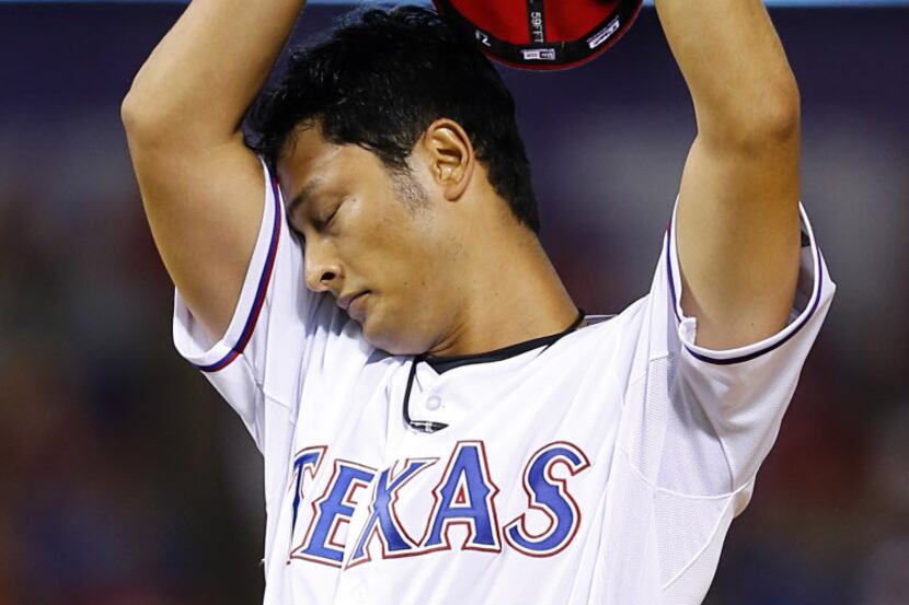 Texas Rangers starting pitcher Yu Darvish (11) wipes his brow after walking Houston Astros...