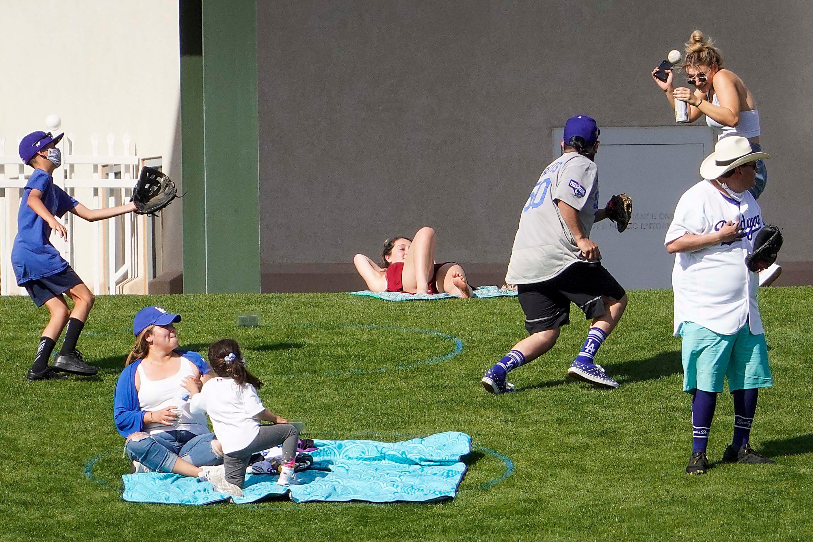 A fan on the outfield lawn ducks away from a home run off the bat of Los Angeles Dodgers...