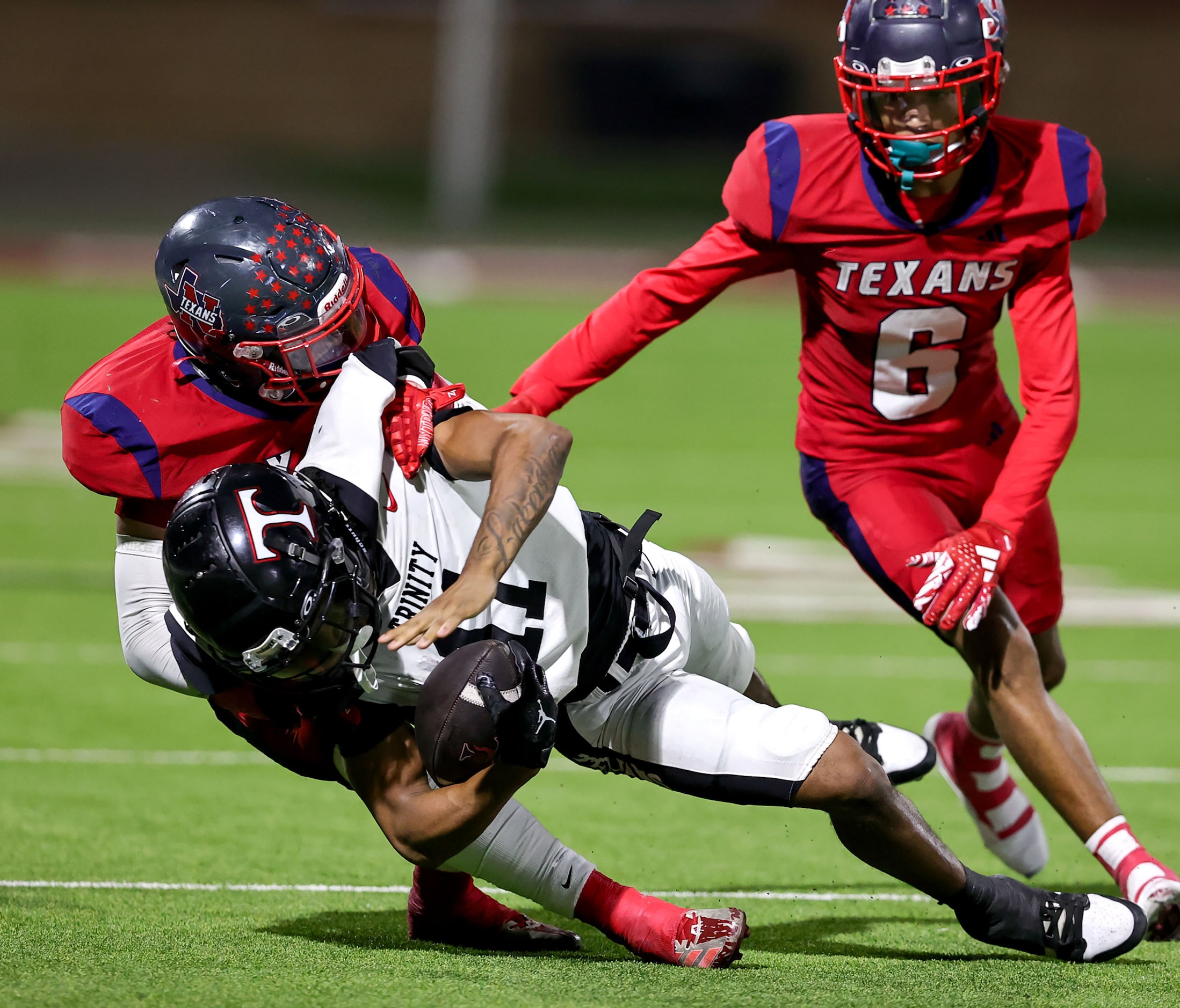 Trinity wide receiver Antwan McGee (11) is hit hard after making a reception by Justin...