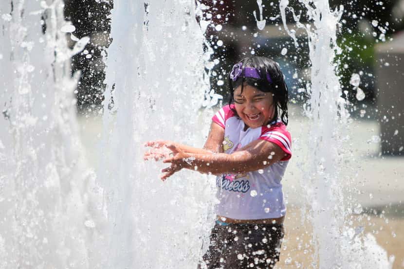 Elizabeth Ramírez de 7 años, juega en una fuente de agua del centro de Dallas. Fotos DMN
