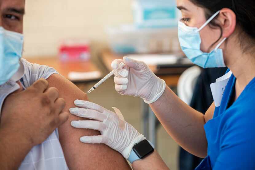 Agustin Duran receives a Pfizer vaccine from registered nurse Pamela Ayala during a pop-up...