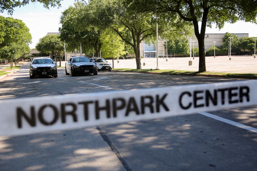Police officers guard the Park Lane entrance to NorthPark shopping center after reports of a...
