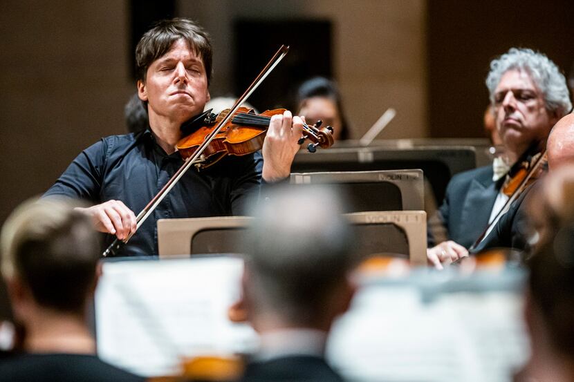 Joshua Bell (left), serves both as the first chair violinist and conductor during a Dallas...