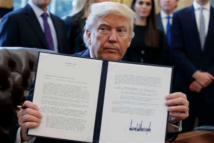 El presidente Donald Trump muestra la firma de la orden ejecutiva que emitió sobre el...