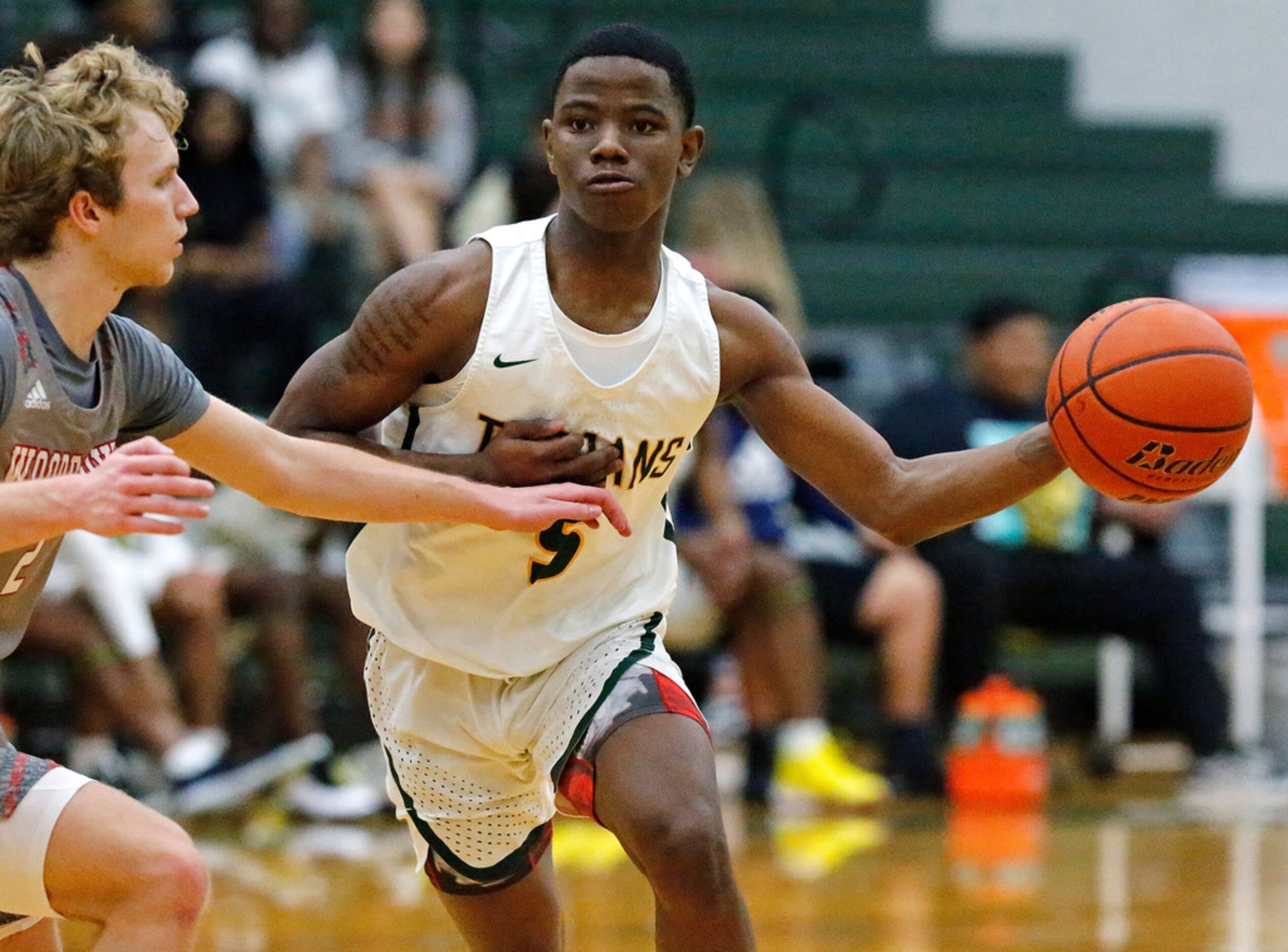 Newman Smith High School guard Devin Peters-Teague (5) makes a pass as he is defended by...