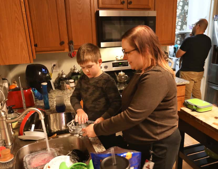7-year-old Henry Sulek, left, Caroline Sulek, and Alex Kennedy do some chores before dinner...