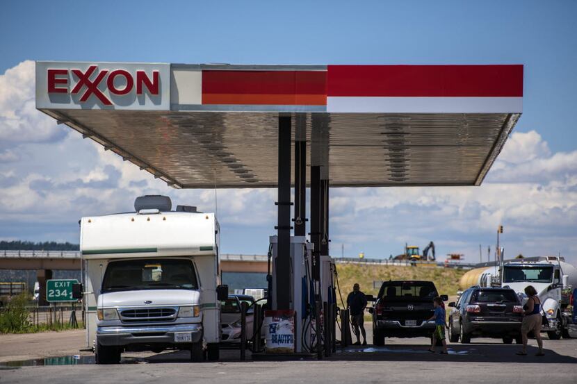 Vehicles refuel at an Exxon gas station outside Aurora, N.M.