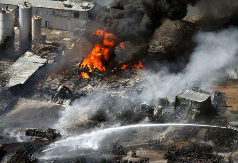 The remains of a charred firetruck (bottom left) were sprayed with water after it caught...