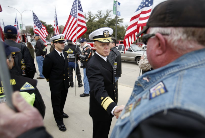 A military leader shakes hands with members of the Patriot Guard Riders before a memorial...