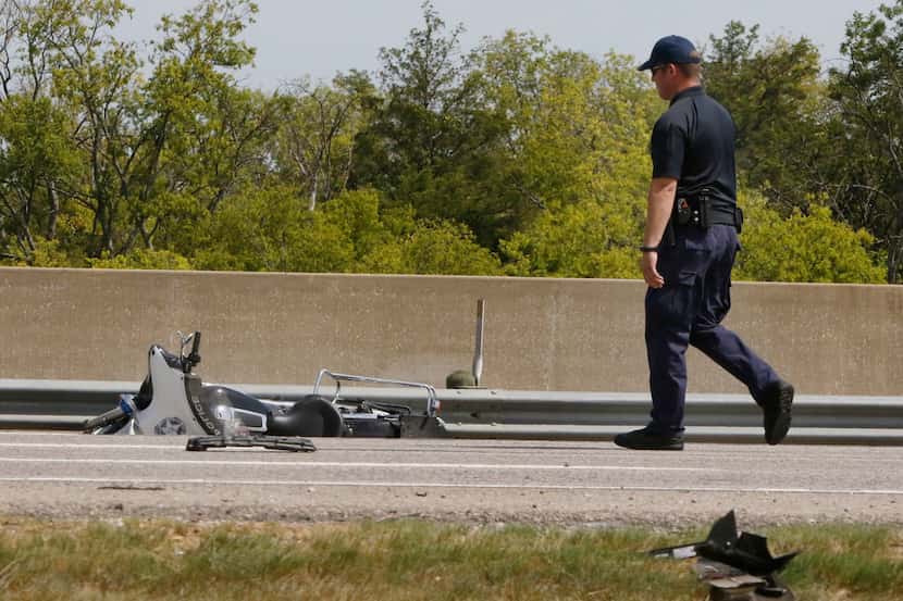 An accident investigator collected evidence Saturday at the crash scene where Dallas police...