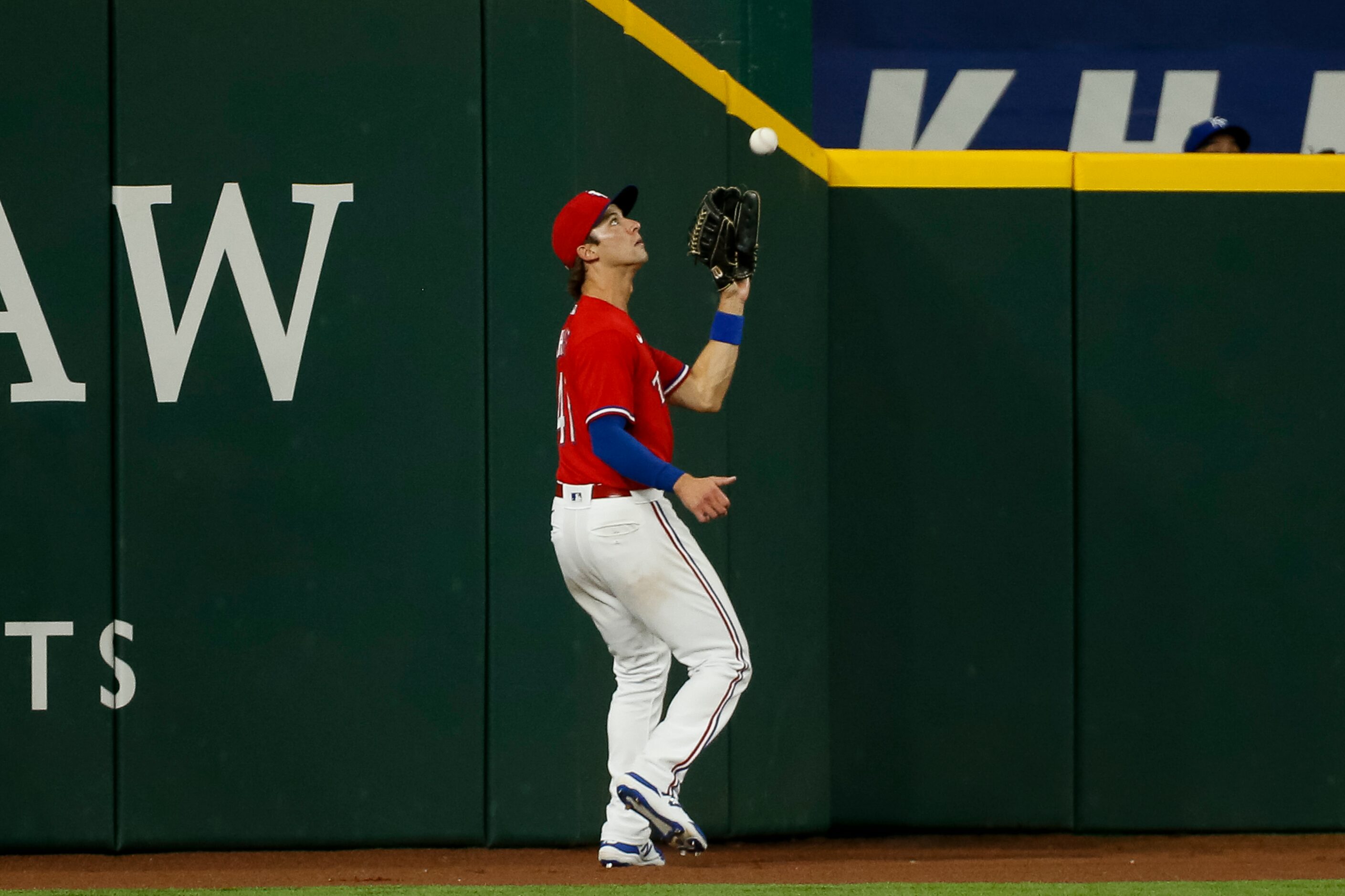 Texas Rangers left fielder Eli White (41) records an out at the warning track during the...