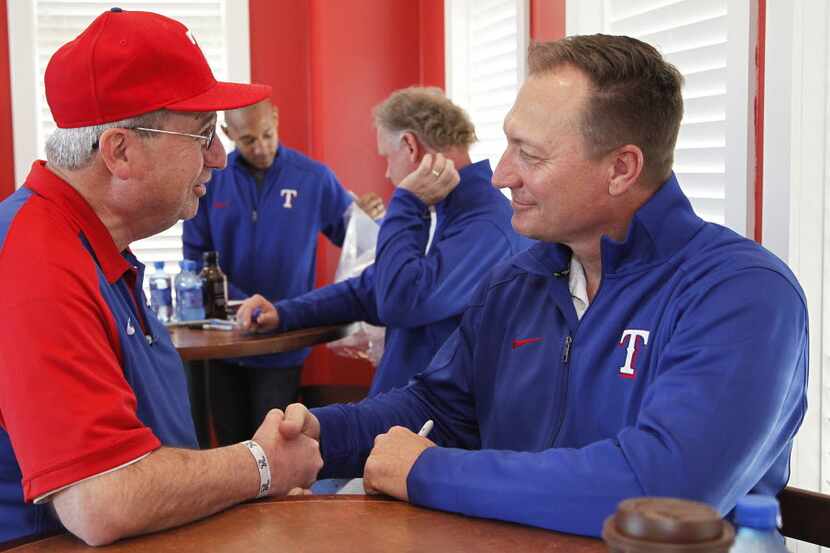 Michael Kearns (left) of The Colony, shakes hands while chatting with Texas Rangers Manager...