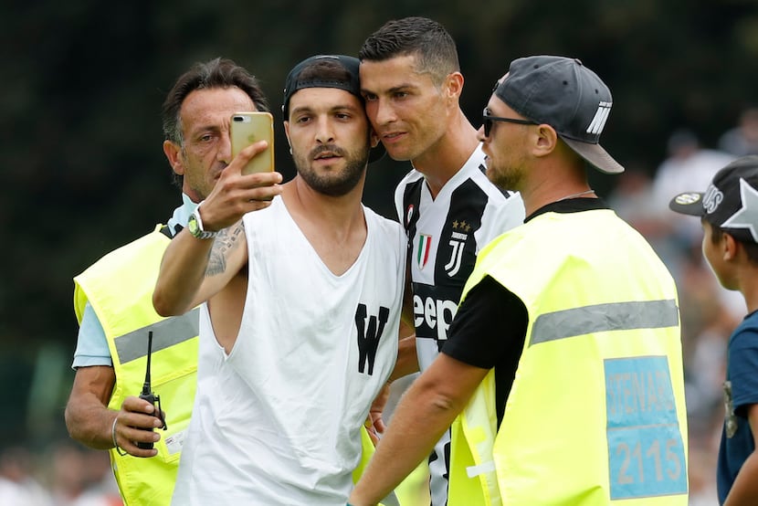A fan takes a selfie photo with Cristiano Ronaldo during a friendly match between the...