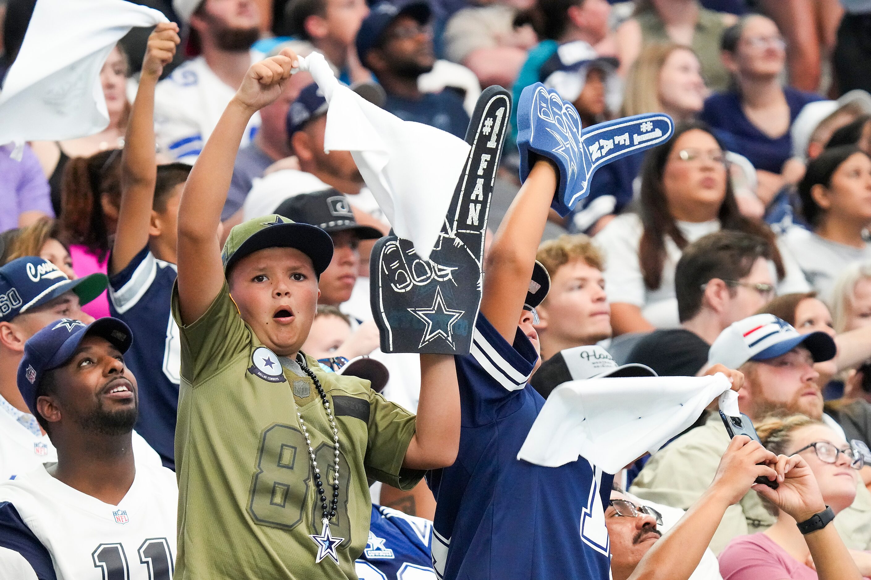 Dallas Cowboys fans cheer their team during the first half of an NFL preseason football game...