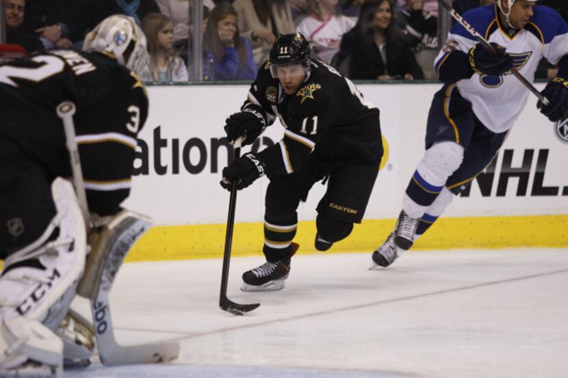 Dallas' Derek Roy takes the puck from St. Louis around the Stars' net during a game versus...
