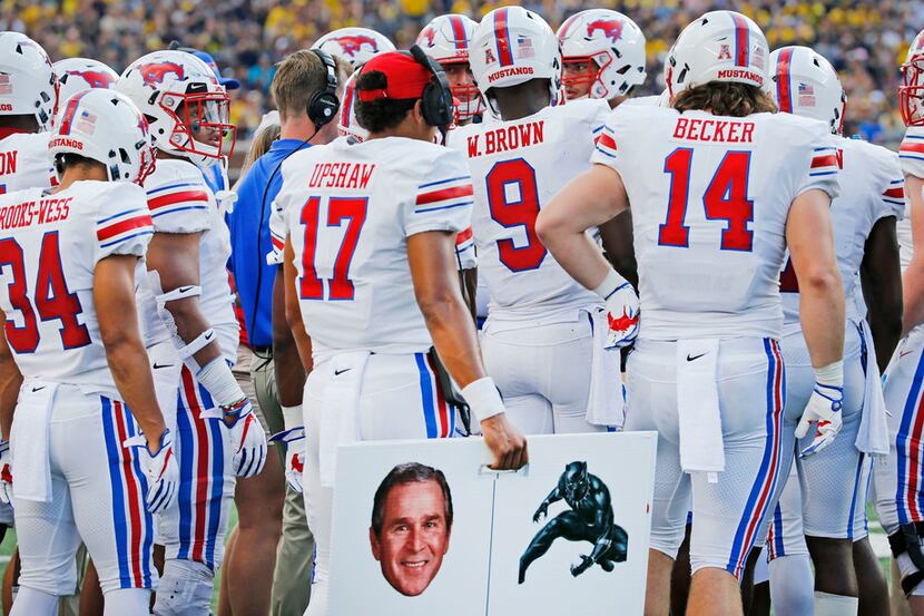 Southern Methodist Mustangs quarterback Austin Upshaw (17) holds a placard containing a...