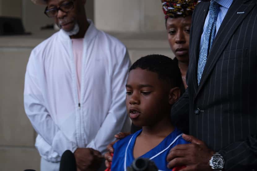 From left, Anthony Johnson Jr.'s father, Anthony Sr. watches as 10-year-old Corbin Johnson...