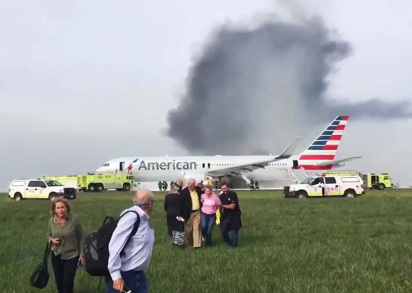 In this file photo, passengers walk away from a burning American Airlines jet that aborted...