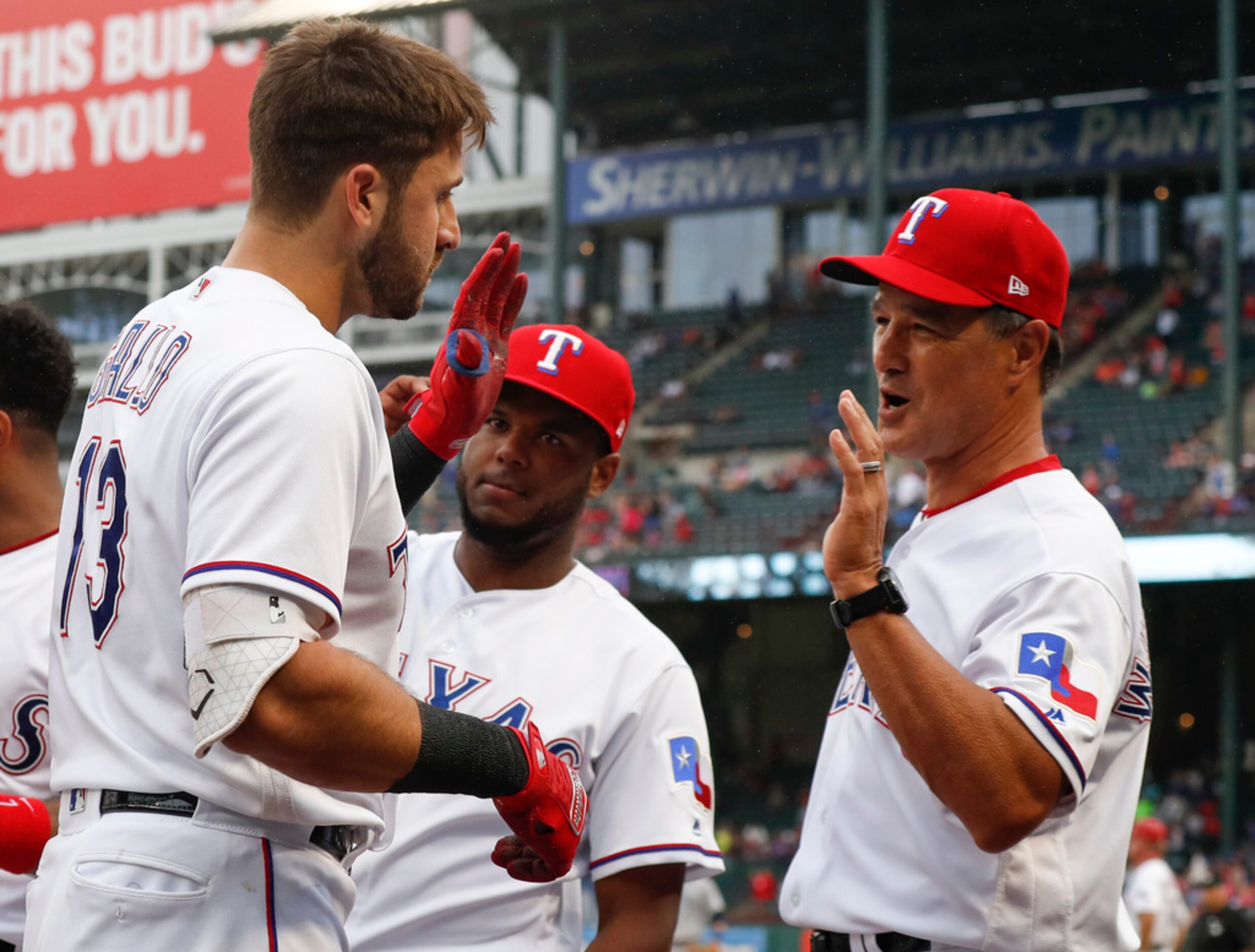 Texas Rangers' Joey Gallo (13) is congratulated by interim manager Don Wakamatsu, right, and...