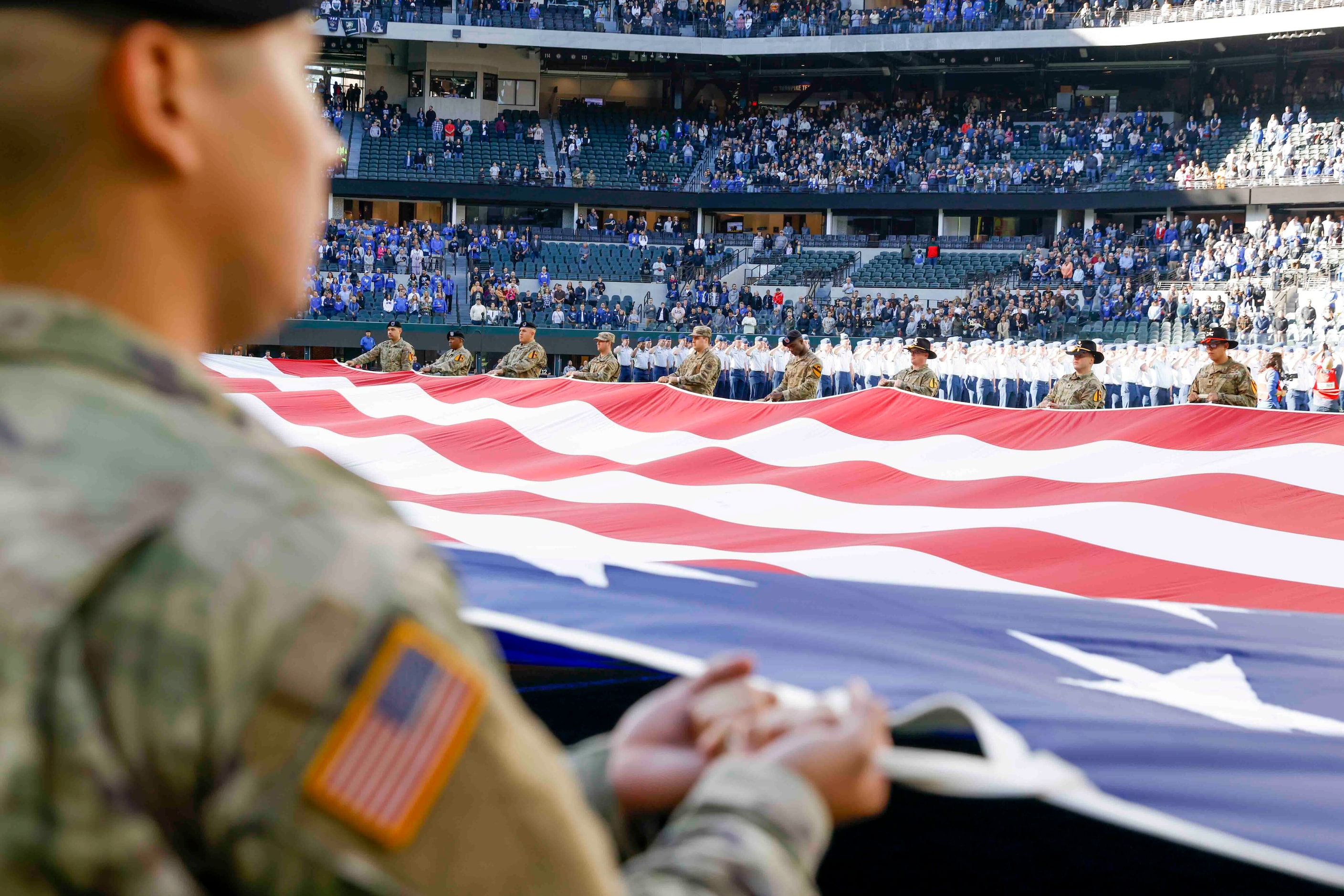 Army cadets display the National flag ahead of an NCAA football game against Air Force at...