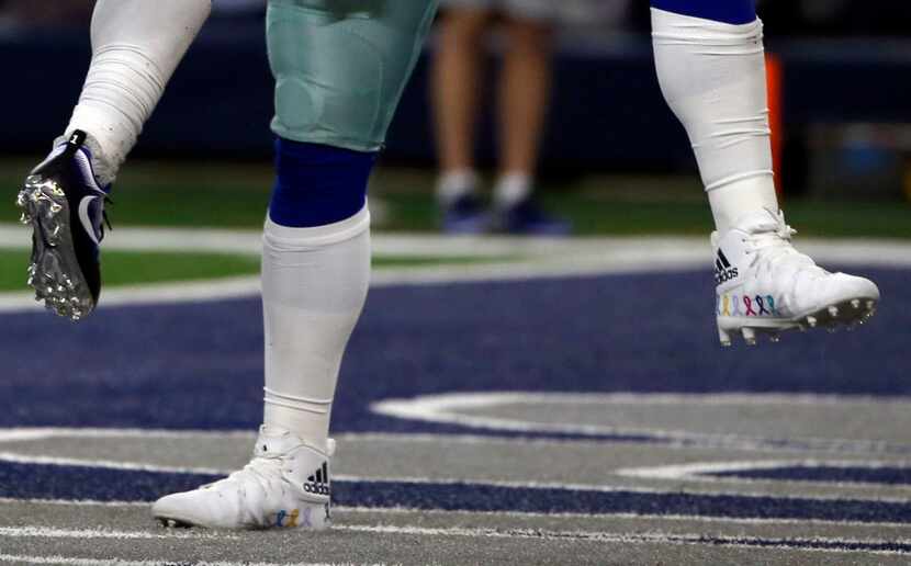 The cleats of Dallas Cowboys' Dak Prescott, right, and Ezekiel Elliott, left, are shown as...