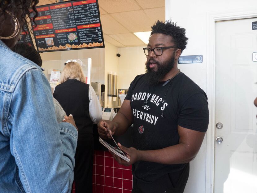 Owner, Gary McMillian of Daddy Mac's Chicken, hands out menus to attendees of the Soul of...