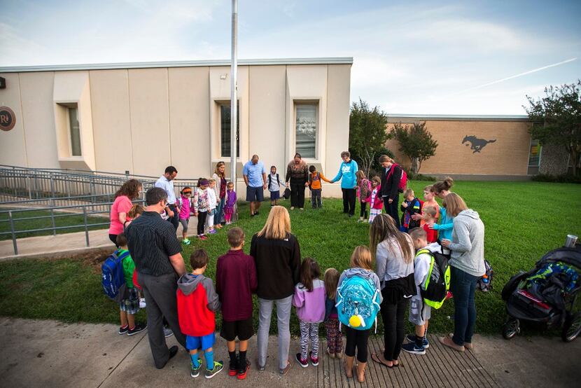 A file photo of students and parents gathering around the flag pole at Bowie Elementary...