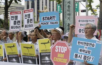 South Korean protesters shout slogans during a rally demanding to stop the joint military...