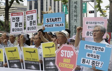 South Korean protesters shout slogans during a rally demanding to stop the joint military...