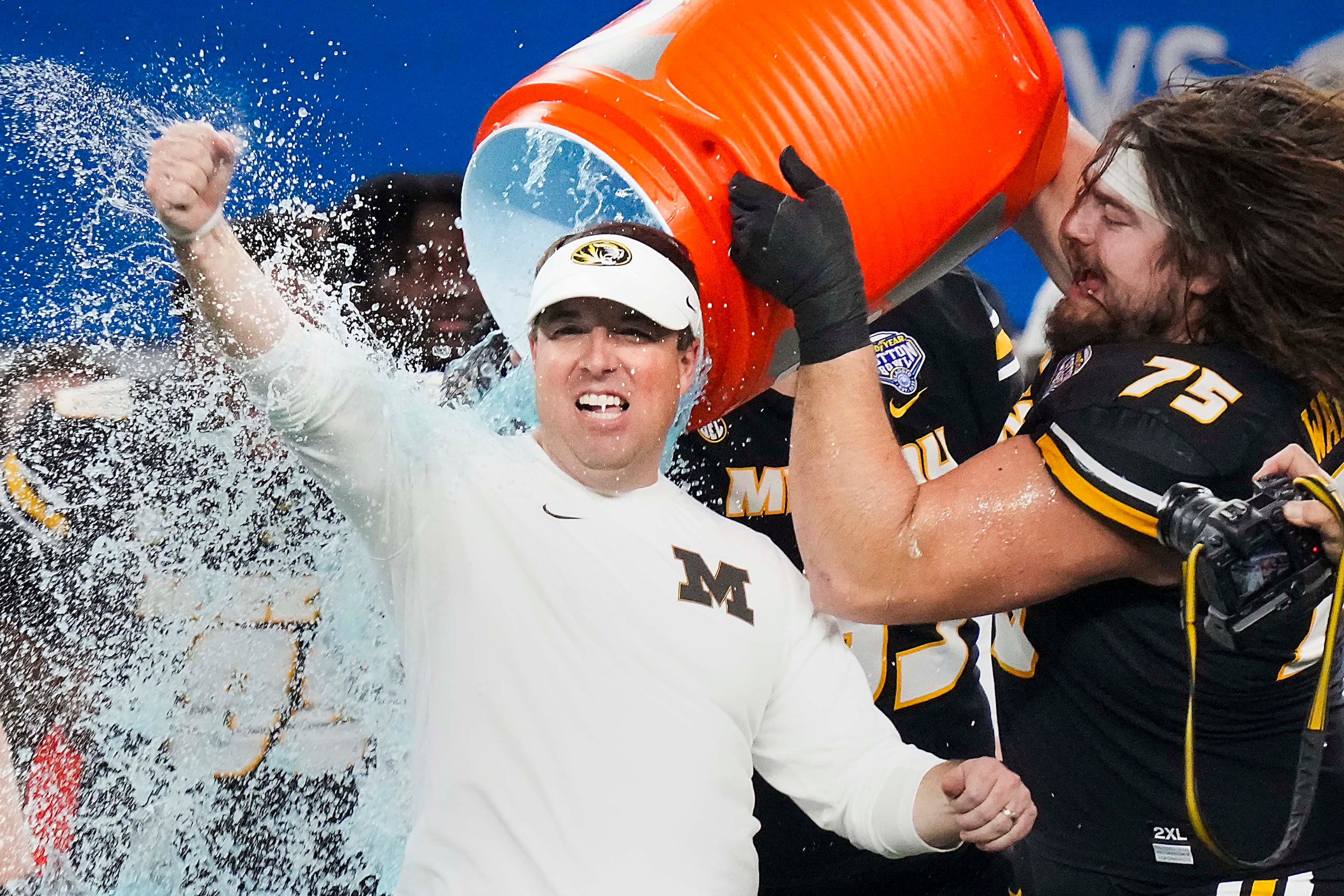 Missouri head coach Eliah Drinkwitz is doused by offensive lineman Mitchell Walters (75)...