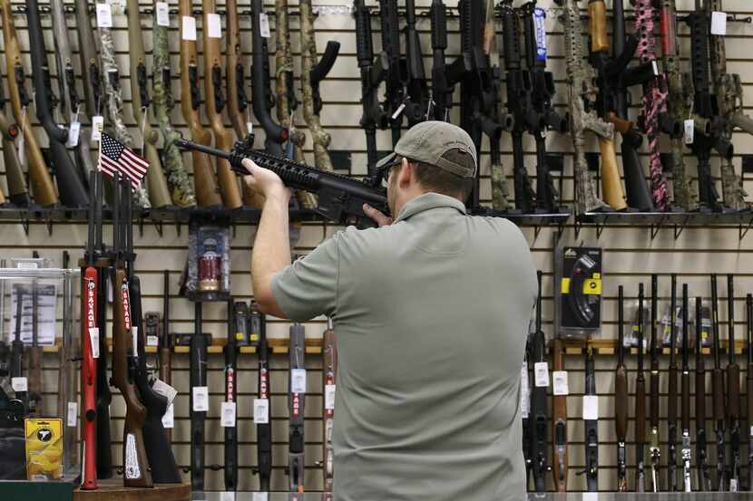 A customer holds a AR-15 riffle for sale at a gun store in Orem, Utah, U.S., on Thursday,...