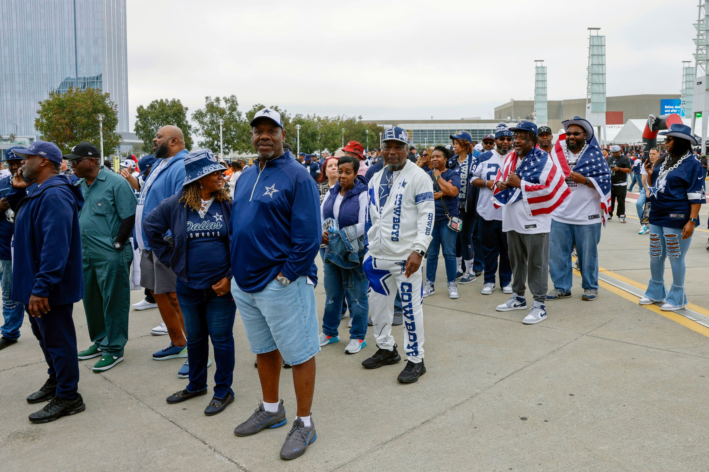 Several Dallas Cowboys wait in line to enter Mercedes-Benz Stadium before a game against the...