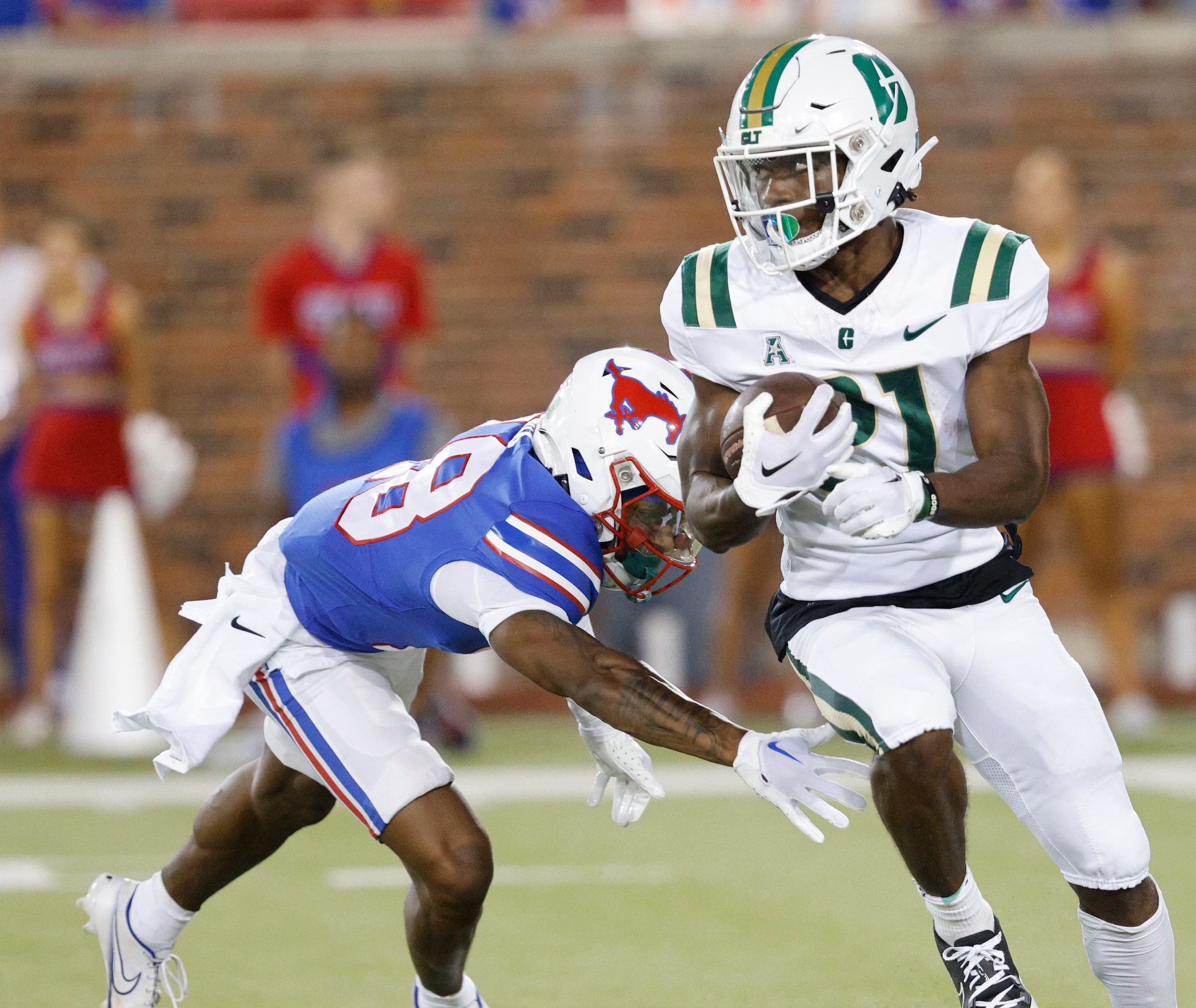 Charlotte 49ers running back Henry Rutledge (21) keeps the ball away from SMU cornerback...