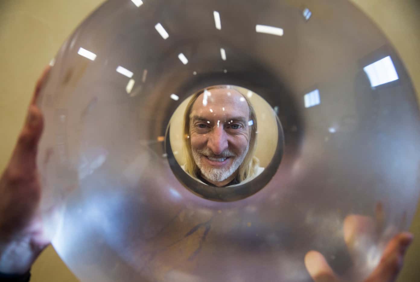 At his home in Dallas, Victor Vescovo peers through one of the windows used in his Triton...