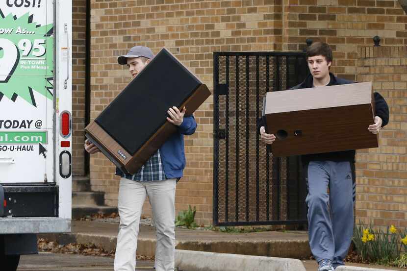  Two men carry speakers from the now closed University of Oklahoma's Sigma Alpha Epsilon...