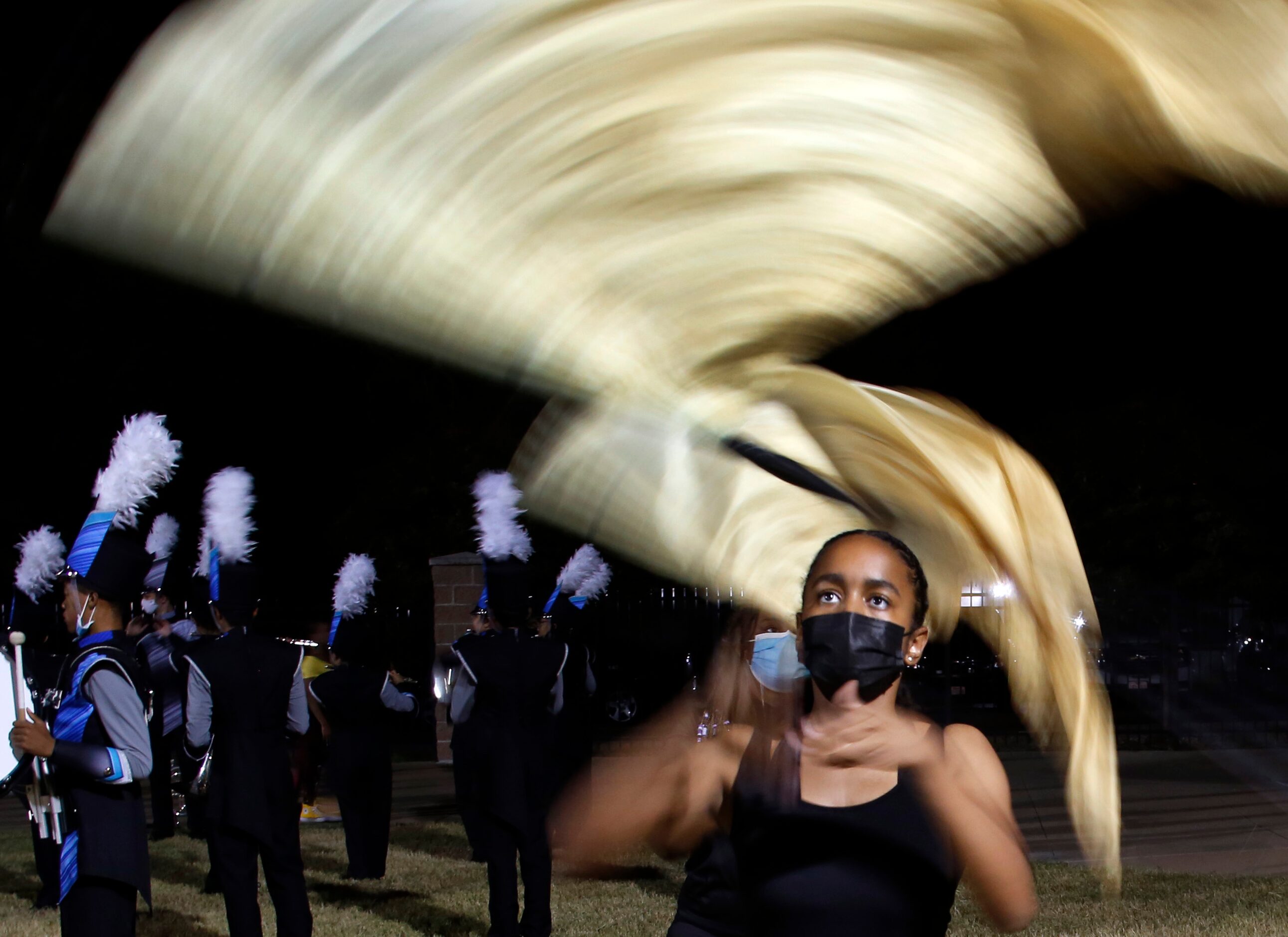 Carrollton Ranchview flag corps member Lauren Lafond focusses as she spins a large flag...