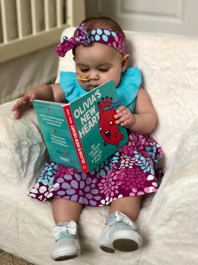 Olivia Solis at almost 8 months, with the book about her life so far
