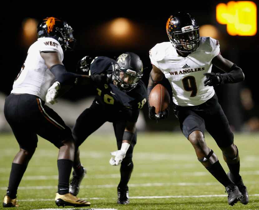 West Mesquite's Dylan Wright (9) carries the ball as JuJu Hargrave, left, blocks Royse...
