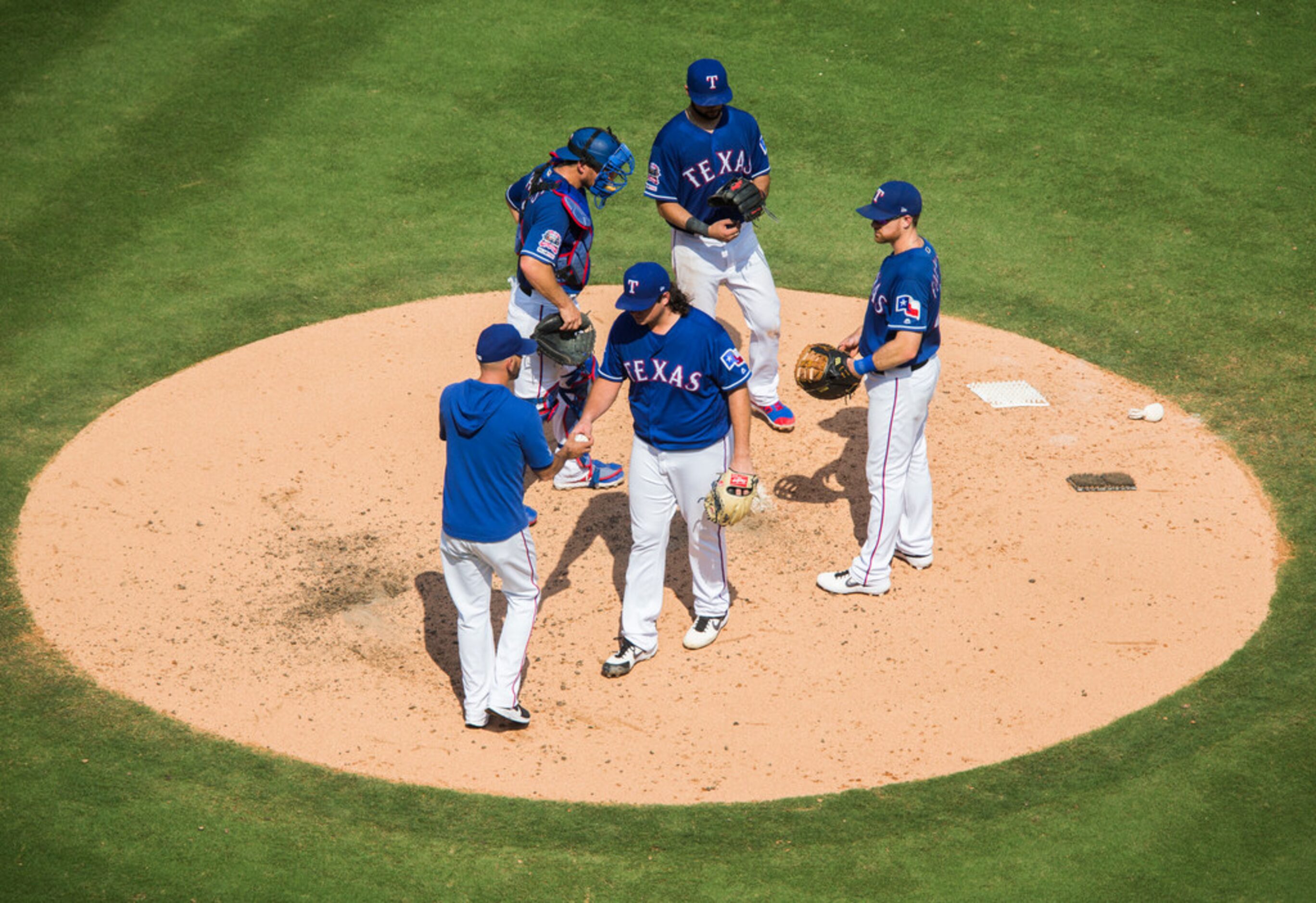 Texas Rangers relief pitcher Ian Gibaut (63) is taken off the mound by manager Chris...