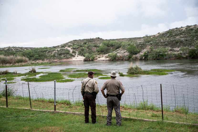 Agentes de la ley vigilan Una sección del Río Grande, cerca de Del Río, ciudad de Texas que...