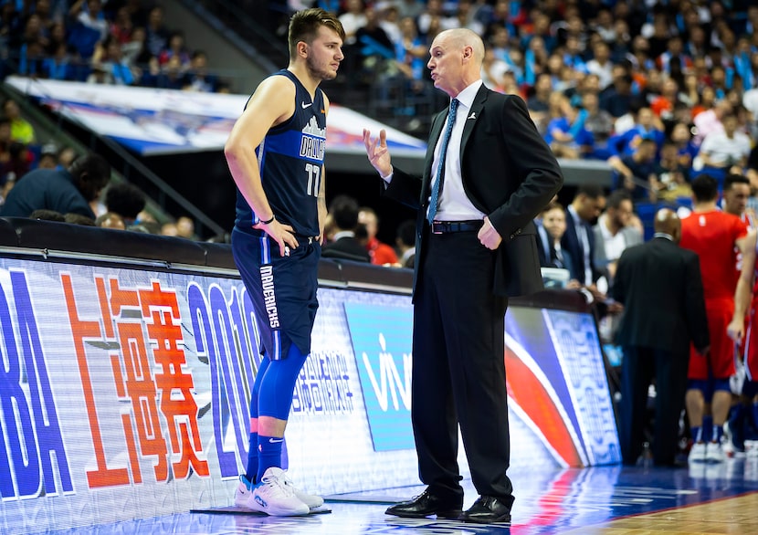 Dallas Mavericks guard Luka Doncic (77) talks with head coach Rick Carlisle before checking...