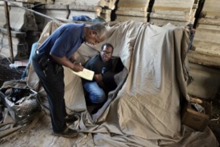  Michael Culpepper, right, gathers a few posessions from his camp under Interstate 45 before...