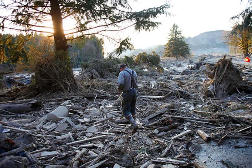 Steve Skaglund walks across the debris field on the east side of Saturday's fatal mudslide...