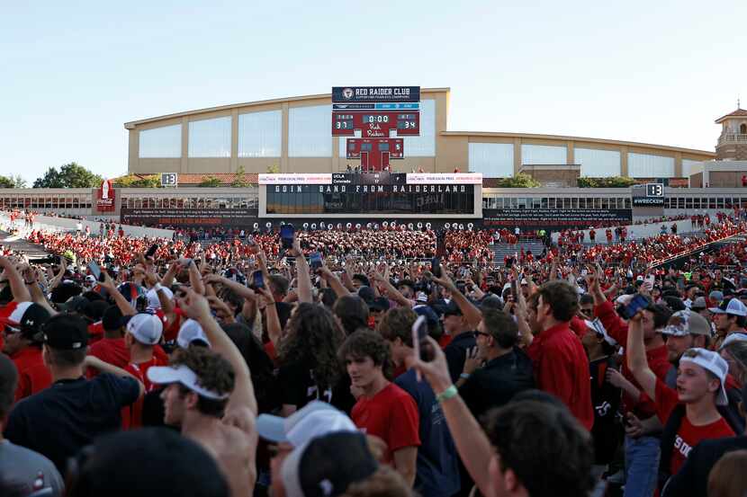 Texas Tech fans celebrate on the field after an NCAA college football game against Texas,...