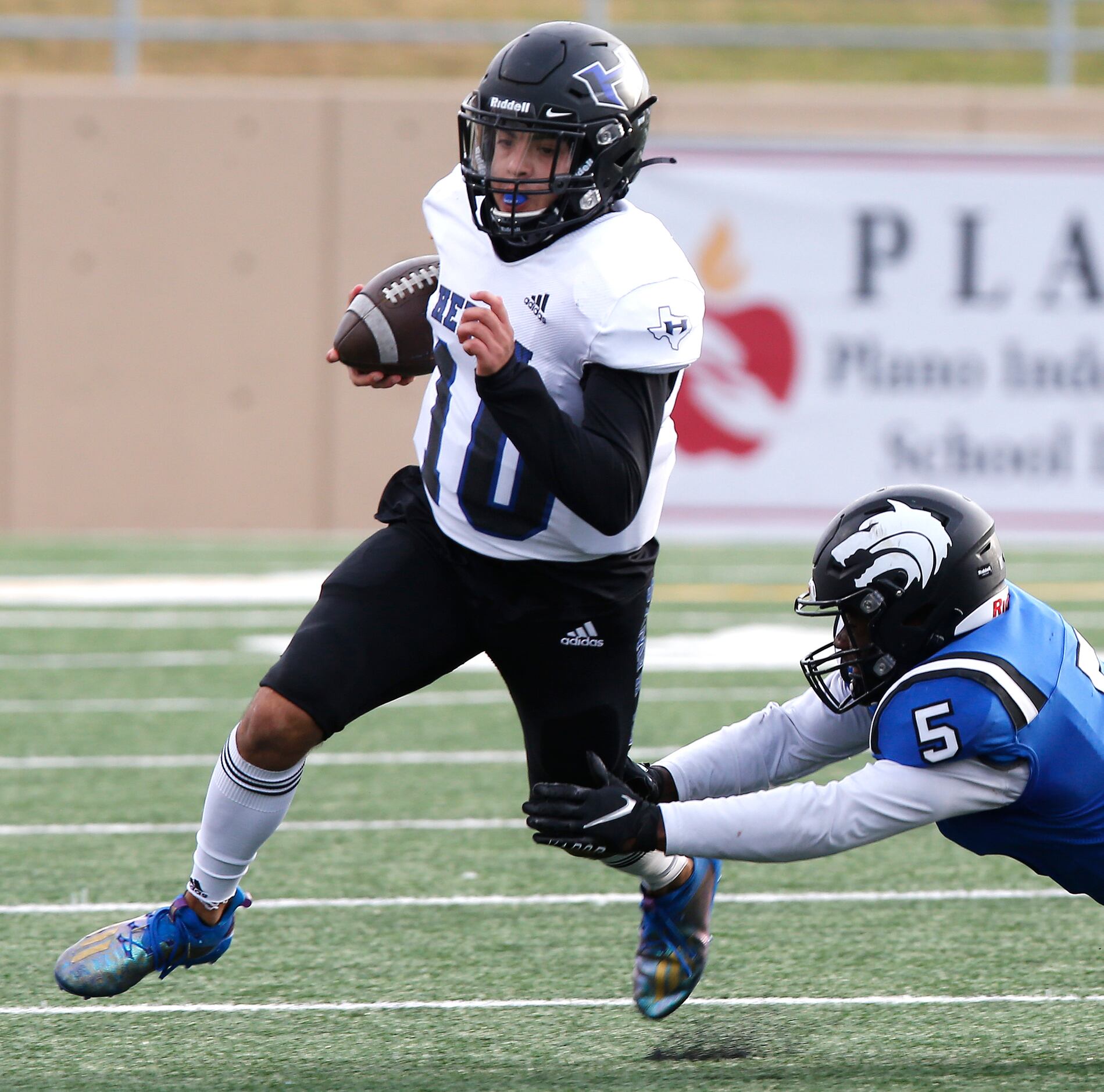 Hebron High School quarterback Jacob Buniff (10) is tripped up by Plano West High School...