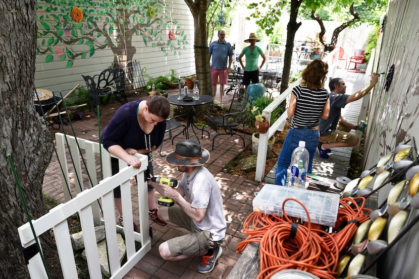 Carrie Perkins (left) and Simon Perkins work together to complete a swinging door on a fence...