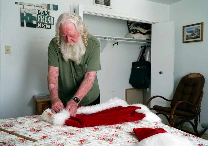 Allen Cole takes out his Santa Claus suit. He says his white beard is real and has been...